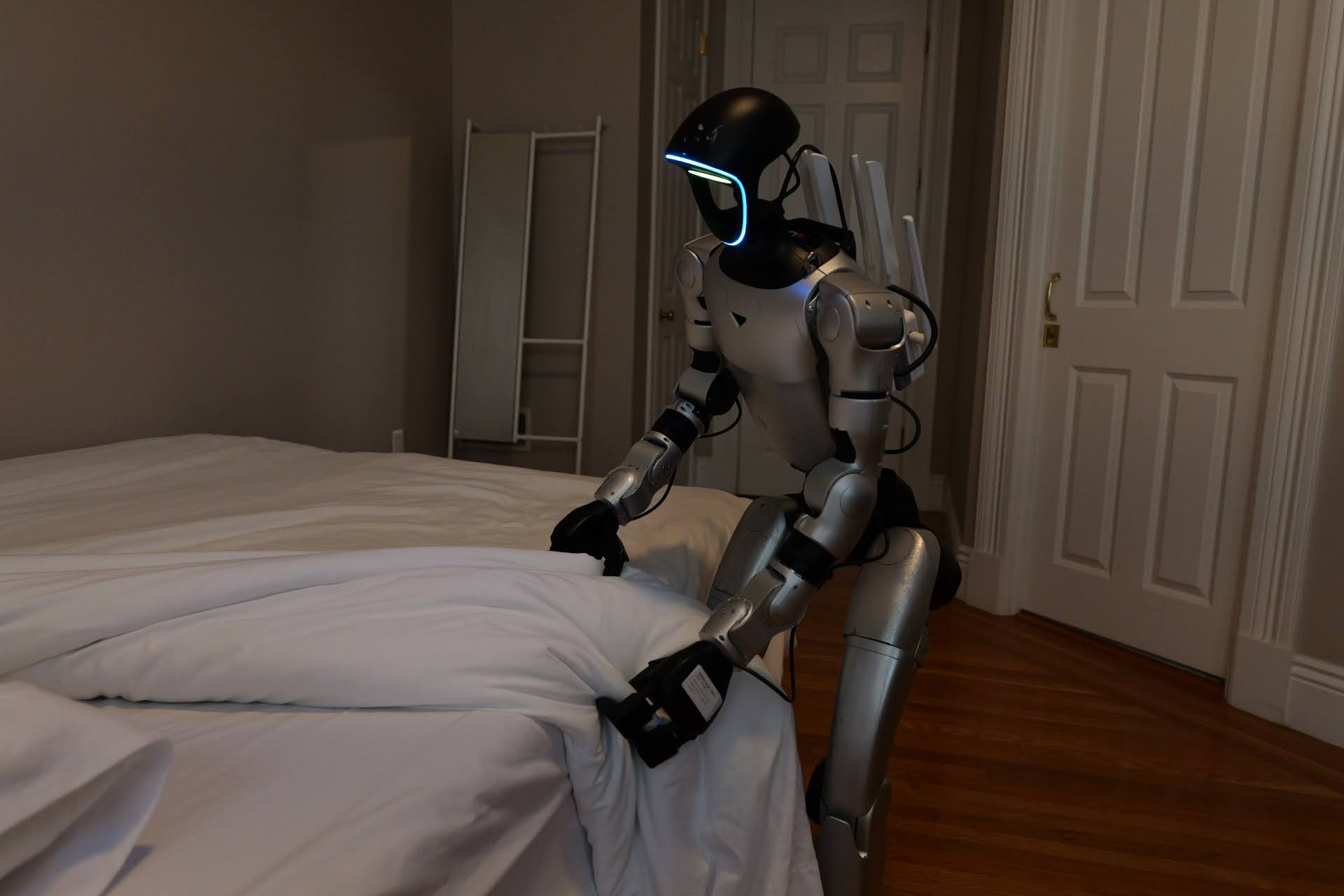 Robot making the bed in a soft-lit bedroom